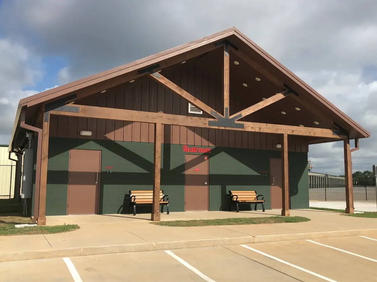 Building exterior with park benches and a restroom sign